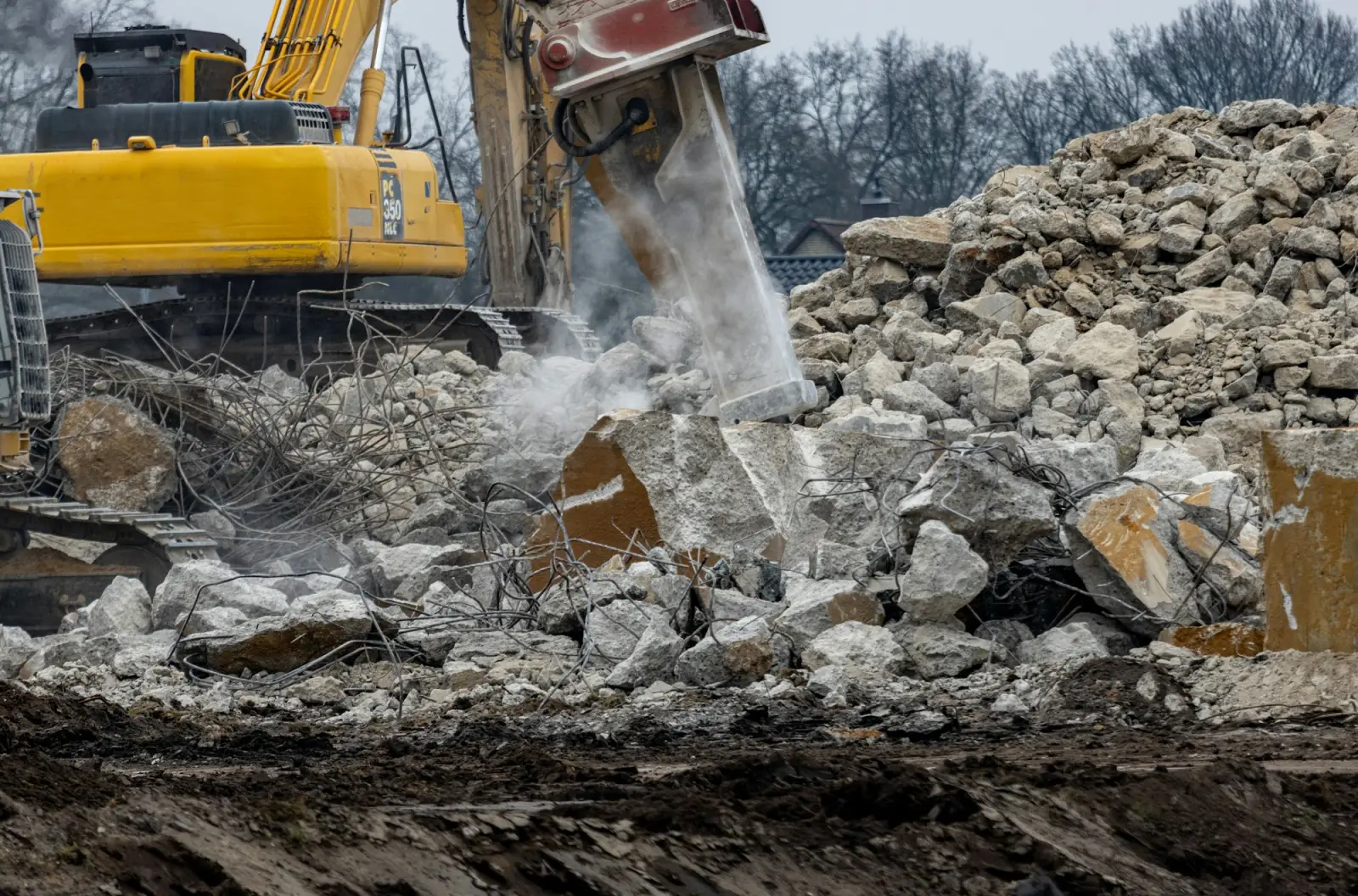 Graafmachine met breekhamer in betonpuin